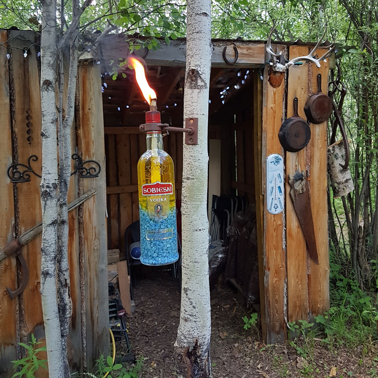 Another of our citronella oil lamps near the wood shed in the Middle of Know-Where